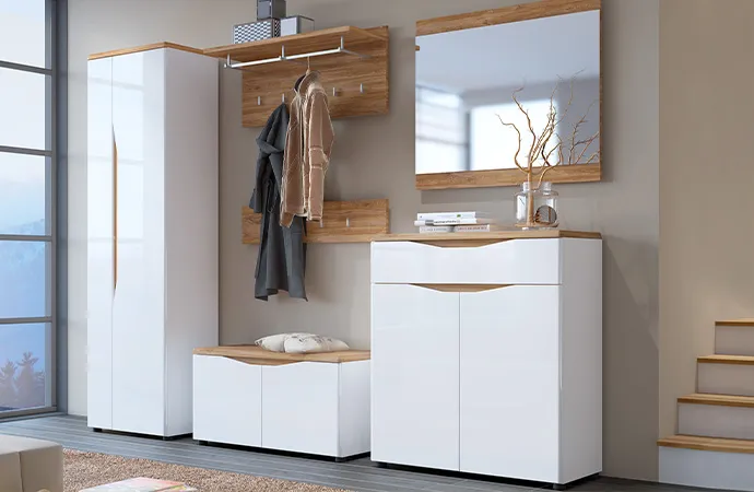 Flur mit weiß-holzfarbigen Flurmöbeln, bestehend aus Dielenschrank, Garderobenpaneel, Bank, Spiegel und Schuhrschrank