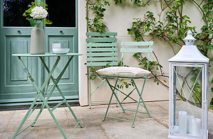 Eine Terrasse mit hellgrünem Balkon-Set.
