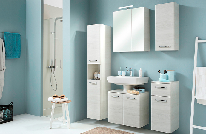 Badezimmer mit wandhängenden Badmöbeln in heller Eichenoptik, bestehend aus Hochschrank, Spiegelschrank, Waschbeckenunterschrank, Hängeschrank und Unterschrank