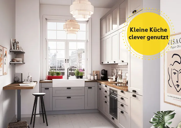 Eck-Küche im Landhausstil in Grau mit schwarzen Griffen mit Hinweis: Kleine Küchen clever genutzt.