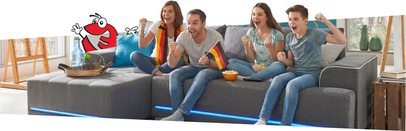 Jubelnde Familie auf grauem Ecksofa Sofa
