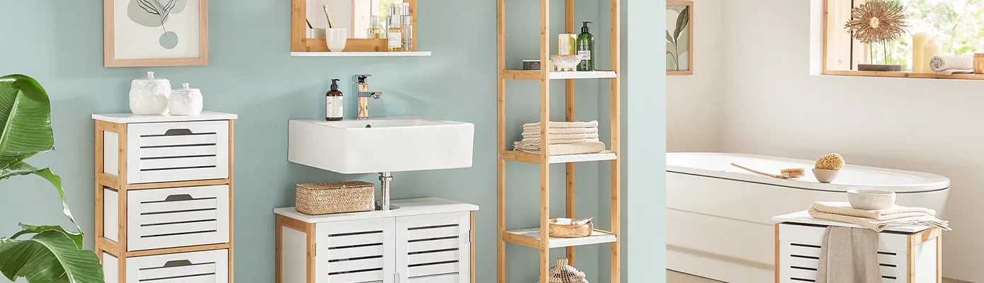 Badezimmer mit Möbeln mit weißen Lamellenfronten und hellem Holzgestell: Schubladenkommode, Waschbeckenunterschrank, Spiegel, Standregal, Wäschetruhe